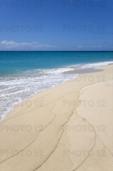 WEST INDIES, St Vincent And The Grenadines, Canouan Island, South Glossy Beach in Glossy Bay with waves breaking on the shoreline of the turqoise sea.