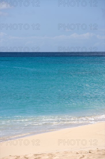 WEST INDIES, St Vincent And The Grenadines, Canouan Island, South Glossy Beach in Glossy Bay with waves breaking on the shoreline of the turqoise sea.