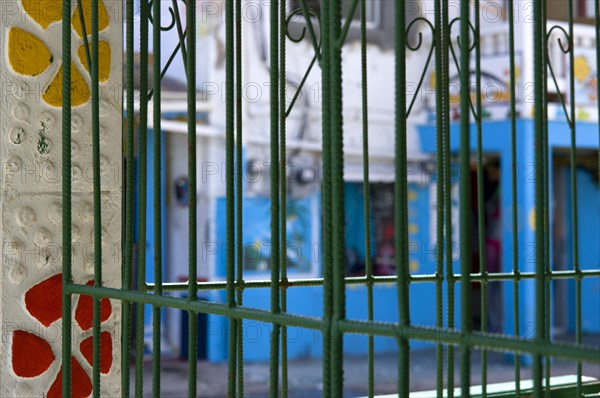 WEST INDIES, St Vincent And The Grenadines, Union Island, Green metal caging on a building in a colourful street in Clifton.