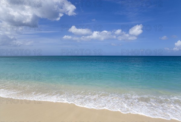 WEST INDIES, Grenada, St George, Waves breaking on the shore at Grand Anse Beach with the turquoise sea beyond