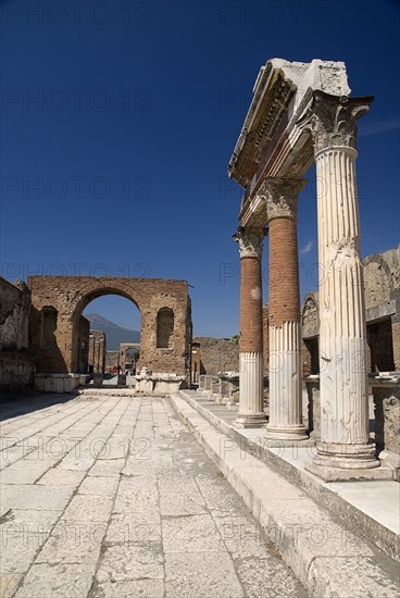 20093681 ITALY Campania Pompeii The Forum. Portico in front of the Macellum with arch in the distance