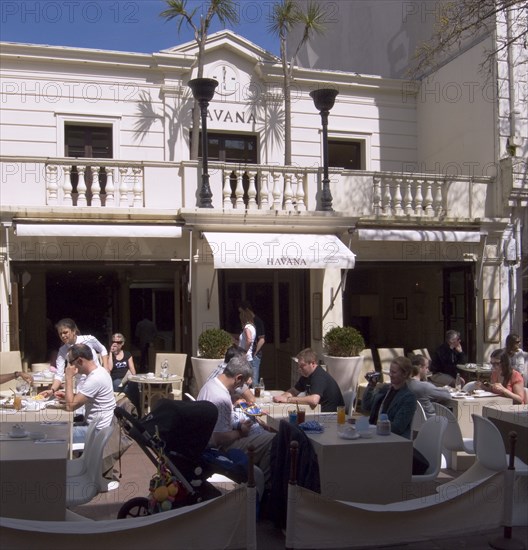 ENGLAND, East Sussex, Brighton, People sat outside the Havana restaurant in Duke Street.