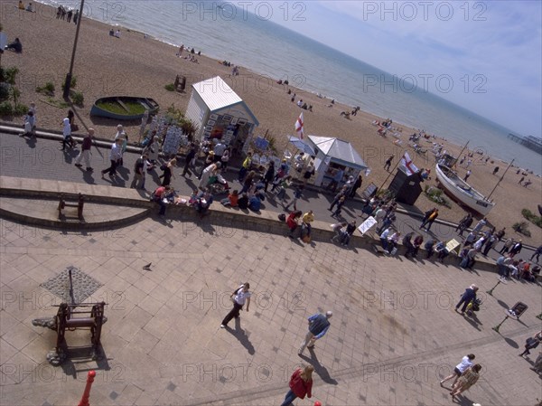 ENGLAND, East Sussex, Brighton, Promenade outside the fishing museum with stall selling fish and beach behind.