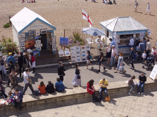 ENGLAND, East Sussex, Brighton, Promenade outside the fishing museum with stall selling fish and beach behind.