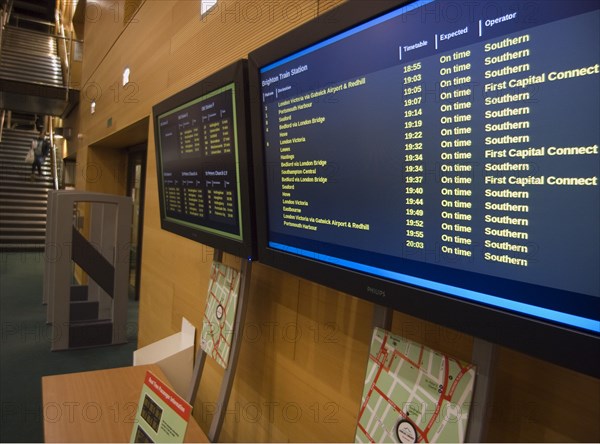 ENGLAND, East Sussex, Brighton, Display of live train and bus times in public library.