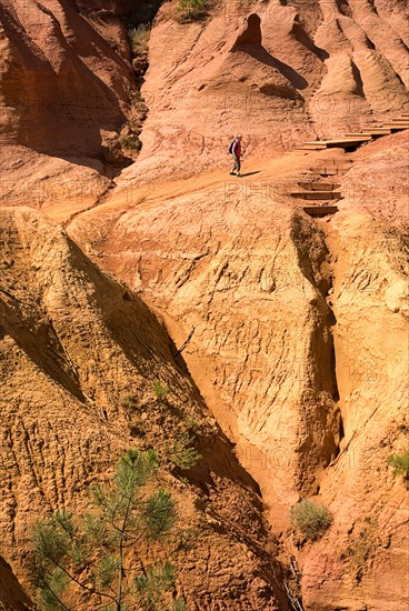 FRANCE, Provence Cote d’Azur, Le Sentier des Ocres (The Ochre Footpath) , Belvedere Panorama area with figure walking on the sandy red trail of the park.