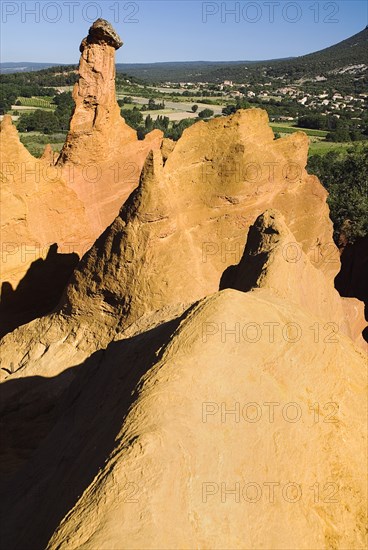 FRANCE, Provence Cote d’Azur, Vaucluse, "Cheminee de Fee or Fairy Chimneys.  Early morning light on eroded, ochre rocks in area known as Colorado Provencal."