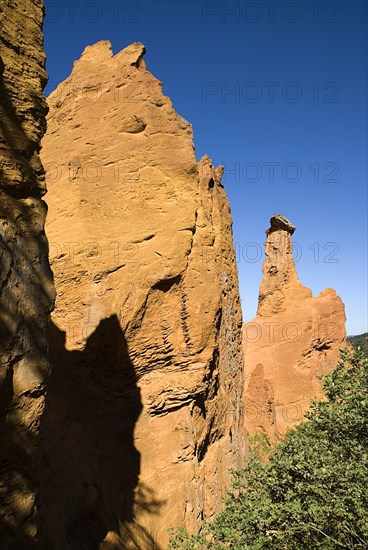 FRANCE, Provence Cote d’Azur, Vaucluse, Cheminee de Fee or Fairy Chimneys.  Morning light on eroded ochre rock pinnacles in area known as Colorado Provencal.