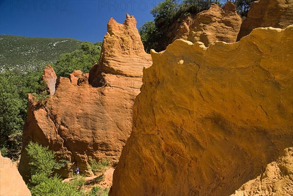 FRANCE, Provence Cote d’Azur, Vaucluse, Colorado Provencal.  Cheminee de Fee or Fairy Chimneys.  Area of eroded ochre rock cliffs and pinnacles from viewpoint.