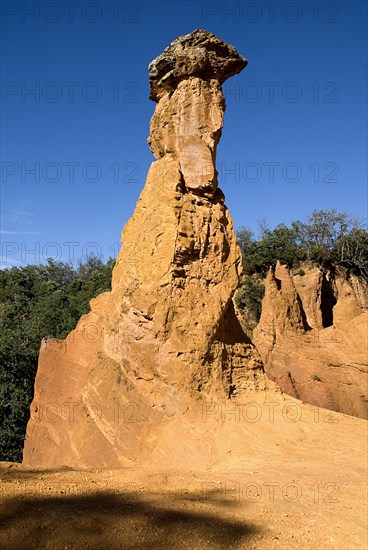 FRANCE, Provence Cote d’Azur, Vaucluse, "Colorado Provencal.  Cheminee de Fee or Fairy Chimneys.  View of capped, eroded ochre rock pinnacle in evening light."