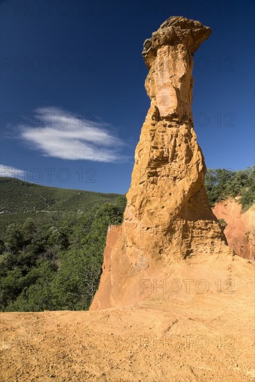 FRANCE, Provence Cote d’Azur, Vaucluse, "Colorado Provencal.  Cheminee de Fee or Fairy Chimneys.  Capped, eroded ochre rock pinnacle in evening light"
