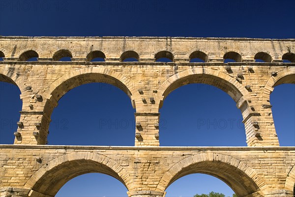 FRANCE, Provence Cote d’Azur, Gard, Pont du Gard.  Close up detail of section of three tiers of continuous arches of Roman aqueduct.