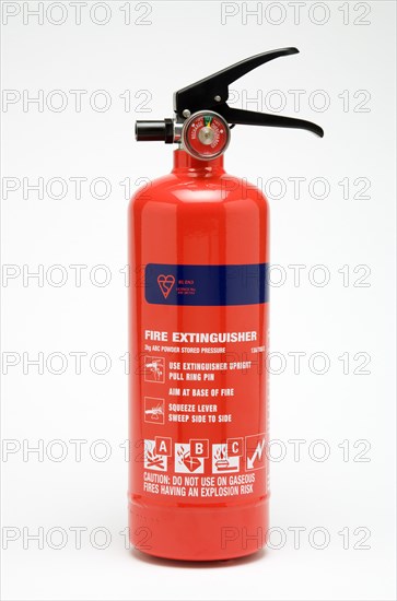INDUSTRY, Health and Safety, Fire, A red ABC category powder fire extinguisher on a white background with usage instructions and warnings printed on the extinguisher body