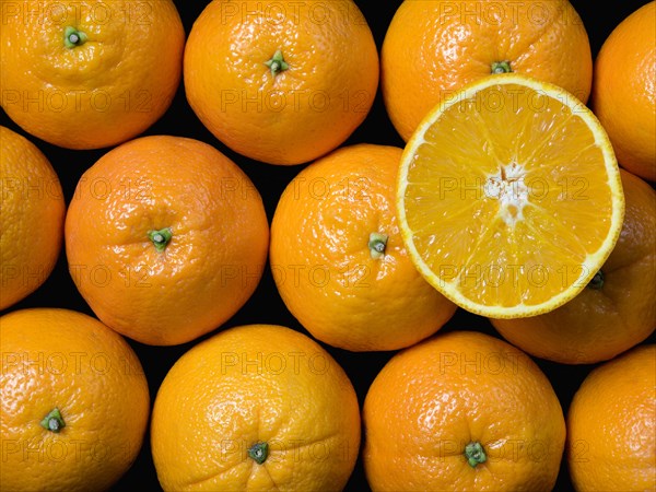 FOOD, Citrus, Fruit, An overhead view down onto a group of oranges with one sliced open on top of the others