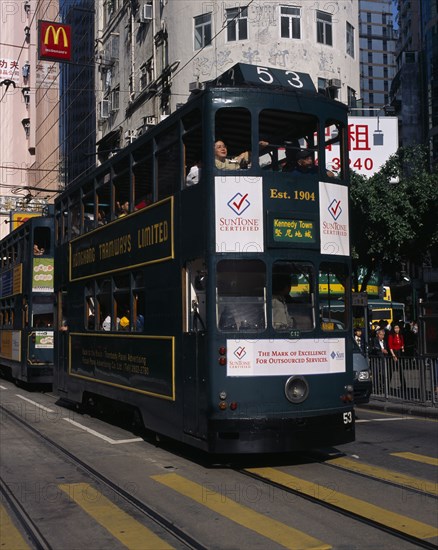 CHINA, Hong Kong, Hong kong Island tram on city street with high rise buildings and advertising hoardings.