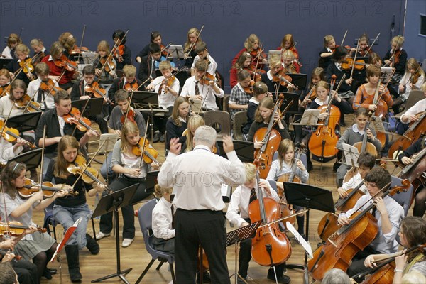CHILDREN, Education, Music, Youth orchestra with conductor in foreground. Sir Michael Tippet giving a music workshop to some young musicians.