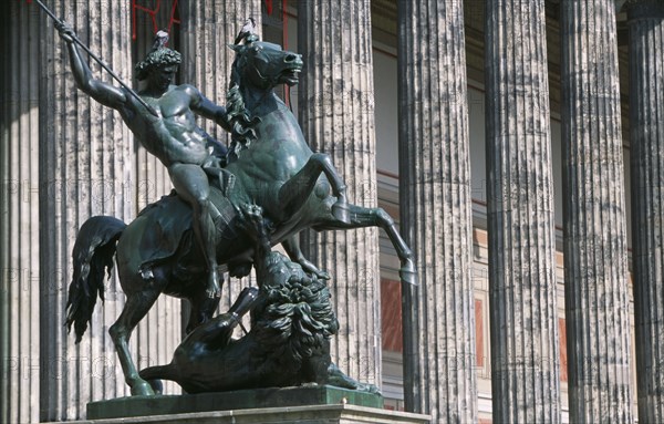 GERMANY, Berlin, Bronze equestrian statue entitled The Lion Fighter by Albert Wolf in 1847 outside colonnaded facade of the Altes Museum designed by Karl Friedrich Schinkel.