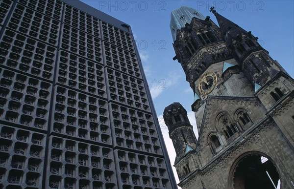 GERMANY, Berlin, Kaiser Wilhelm Memorial Church.  Part view of ruined gothic exterior with clock face beside new building.