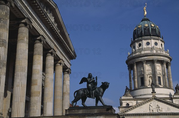 GERMANY, Berlin, Gendarmenmarkt.  Statue of winged Bacchus riding a panther in front of the Konzerthaus with the Franzosischer Dom on right.
