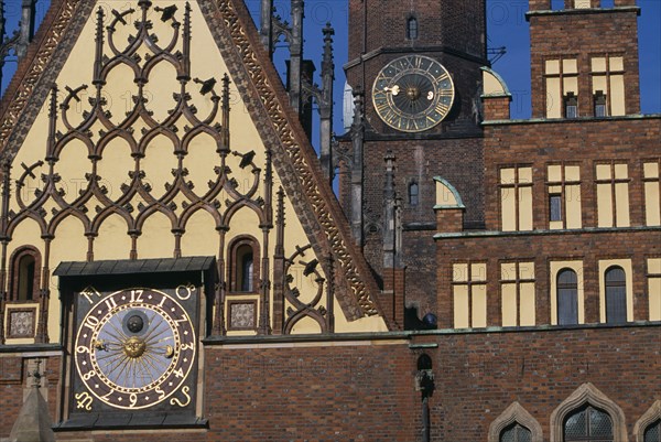 POLAND, Wroclaw, Wroclaw Town Hall dating from the fourteenth century.  Part view of exterior with decorative gable  brickwork and astronomical clock with clock tower behind.