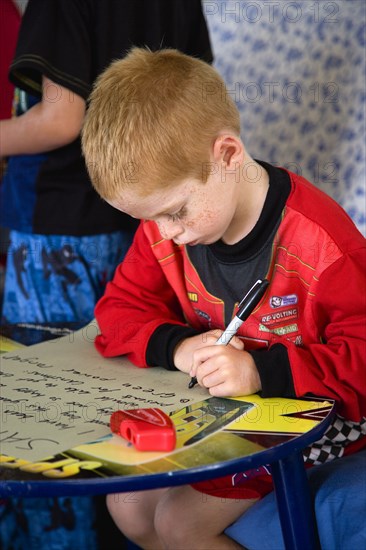 RELIGION, Festivals, Christmas, Young left handed boy at Christmas Eve sitting down and writing his Santa List at a table