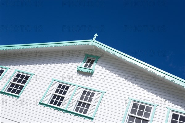 WEST INDIES, Grenada, Carriacou, White timber clapperboard front of a house with turquoise green painted details