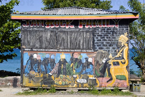 WEST INDIES, Grenada, Carriacou, Colourful Rastafarian food hut called Jam Rock Cafe on the beach in Hillsborough decorated with a Rastafarian Last Supper and Emperor Haile Selassie painted on it and the words May The Lord of Lords Bless and Keep Us Always