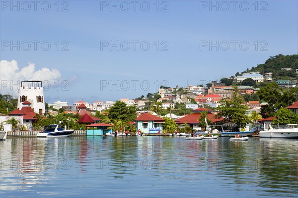 WEST INDIES, Grenada, St George, The new Peter de Savary marina development of Port Louis with the capital city of St George's beyond. Eco tourists in rubber dingies leave the jetty to explore the coastline