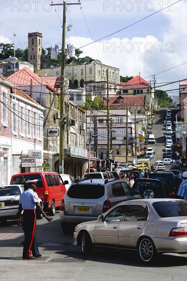 WEST INDIES, Grenada, St George, Male corporal of the Royal Grenadian Police Force directs traffic in busy Market Street in the capital city of St George's
