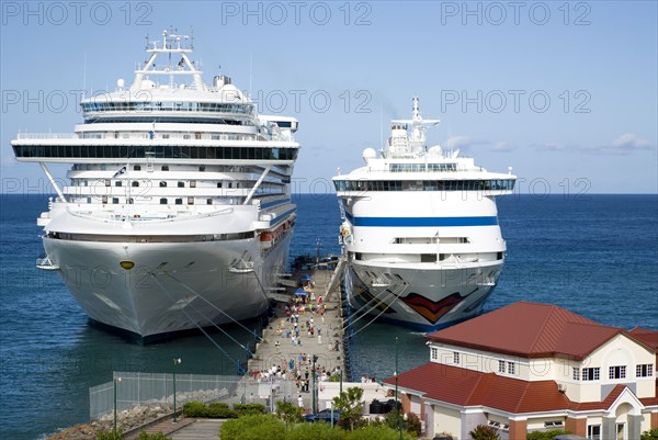 WEST INDIES, Grenada, St George, Two cruise ships the Caribbean Princess and Aida Aura moored at the cruise ship terminal in the capital city of St George's with passengers walking along the jetty between the liners