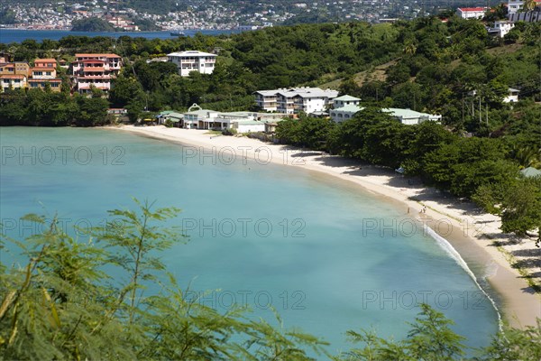 WEST INDIES, Grenada, St George, The aquamarine sea and tree lined white sand of BBC Beach in Morne Rouge Bay with the capital city of St George's in the distance