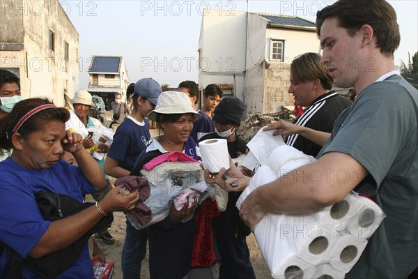 THAILAND, Phang Nga District, Nam Khem, "Tsunami. Thai's who have been homeless receive suplies from the NGO group Family International based in the USA?. In the village of Nam Khem, where 2500 people are pressumed dead, about 125kms north of Phuket. Nothing is left standing in the village on the 2nd Jan."