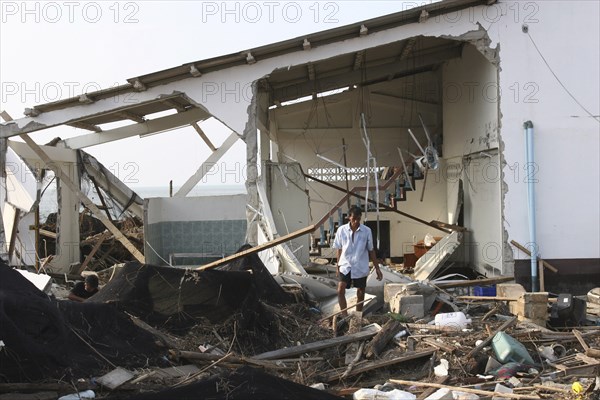 THAILAND, Phang Nga District, Nam Khem, "Tsunami. A man stands outside of what is left of his house and tries to salvage what he can from the damage caused by the tsunami, nothing is left standing in the village 2500 people are pressumed dead 125kms north of Phuket on the 2nd Jan"