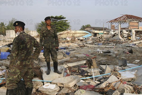 THAILAND, Phang Nga District, Nam Khem, "Tsunami. Thai Army soldiers who has been helping in the clean up at the devestated village caused by the tsunami also look for any bodies, nothing is left standing in the village. 2500 people are pressumed dead. I 125kms north of Phuket on the 2nd Jan."