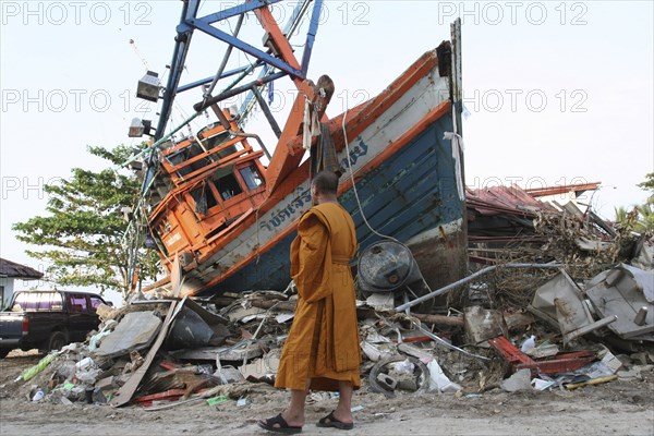 THAILAND, Phang Nga District, Nam Khem, "Tsunami. Monk looks at the damage caused by the tsunami, nothing is left standing in the village 2500 people are pressumed dead. 125kms north of Phuket on the 2nd Jan."