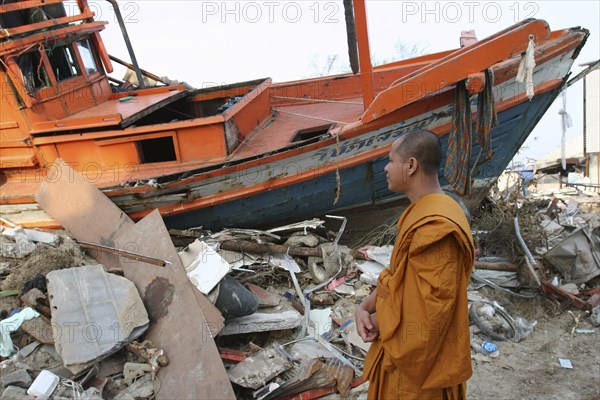 THAILAND, Phang Nga District, Nam Khem, "Tsunami. Monk looks at the damage caused by the tsunami, nothing is left standing in the village 2500 people are pressumed dead. 125kms north of Phuket on the 2nd Jan."