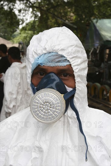 THAILAND, Phang Nga District, Takua Pa, "Tsunami. Forensic people and volunteers have to wear masks and suits to work in the area where the bodies are kept for DNA testing for the sanitation, They are also sprayed down when leaving the area. At the temple Wat Yan Yao."