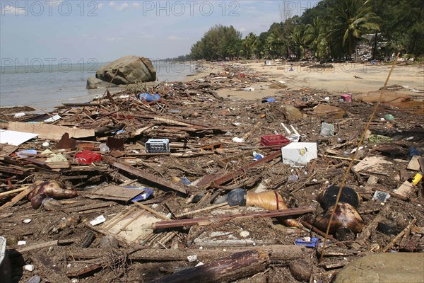 THAILAND, Phuket, "Tsunami. Bodies lay mixed with all the debris on the beach caused by the dissaster. Now the devestation can be seen in the remote areas. This was about 60kms north of Phuket at Khaolak Beach with the destruction of Khaolak Resort in the background, where the whole coastline looks like this and bodies are being found all the way along. On the 28th Dec."