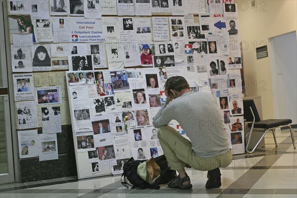 THAILAND, Phang Nga District, Phuket, "Tsunami. A french tourist grieves while looking at pictures of french people missing along with hundereds of others posted up at the Bangkok Phuket hospital, on the 5th Jan."
