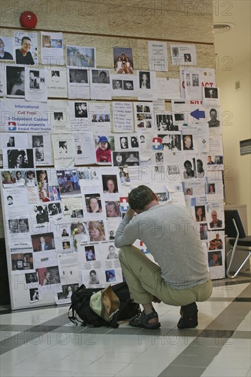 THAILAND, Phang Nga District, Phuket, "Tsunami. A french tourist grieves while looking at pictures of french people missing along with hundereds of others posted up at the Bangkok Phuket hospital, on the 5th Jan."