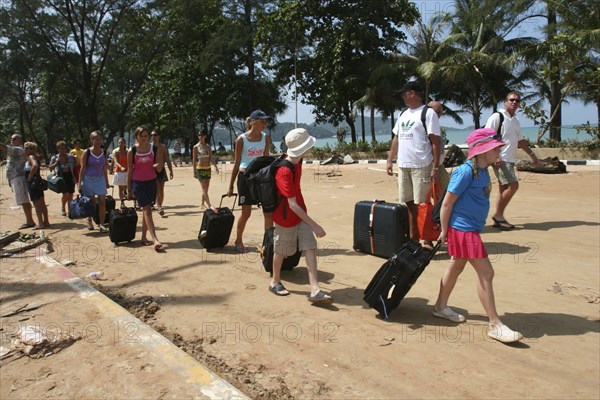 THAILAND, Phang Nga District, Phuket, "Tsunami carnage the day after. Tourists leaving with what they have left in Patong on beach road. Patong is the busiest part of Phuket with hotels, bars, and shops in a very tightly condensed area, and being peak season had thousands of tourists in the area. On the 27th Dec"