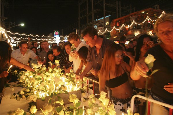 THAILAND, Phuket, Tsunami. Thai's and foreigners pay respect and have a vigil for the dead with candels and flowers in the heart of Patong on new years eve at midnight on the 31st Dec.