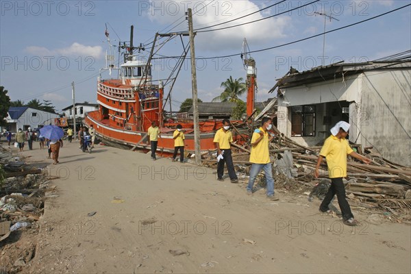 THAILAND, Phang Nga District, Nam Kem, "Tsunami. Volunteers and the locals walk past a fishing boat ploughed into a house. The damage caused by the tsunami, nothing is left standing in the village, about 125kms north of Phuket on the 31st Dec."
