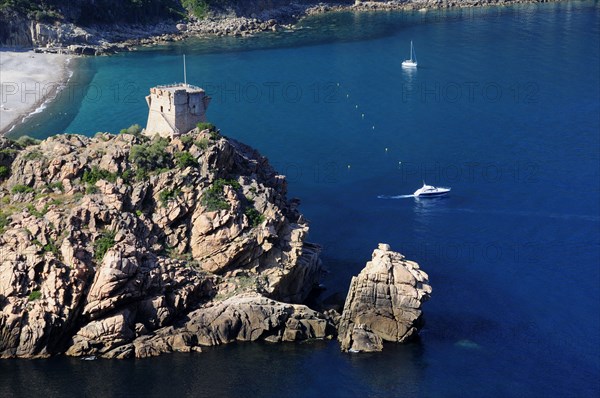 FRANCE, Corsica, Golfe Di Porto, "Porto, Genoese tower on rocky headland with blue waters & boats"