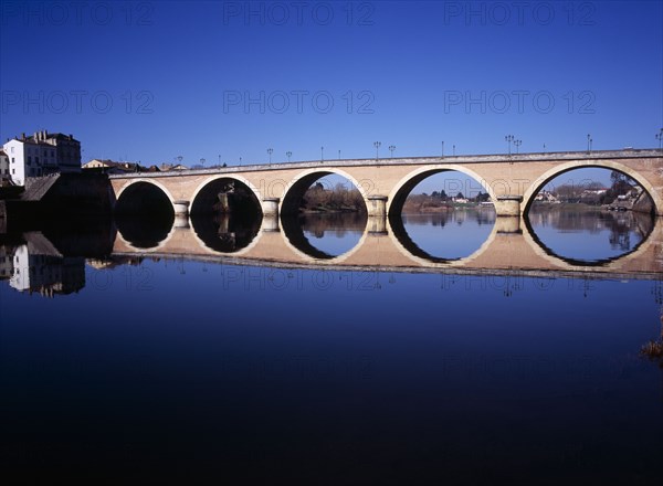 FRANCE, Dordogne, Perigeux, Bergerac. Old bridge over River Dordogne with its reflection on the water.