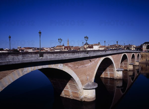 FRANCE, Dordogne, Perigeux, Bergerac. View along old bridge crossing River Dorgogne from south with town beyond.
