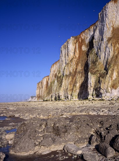 FRANCE, Picardie, Mers les Bains, View north east from rocky foreshore at sea level towards chalk cliffs of the channel coast near and above the town of  Mers les Bains.