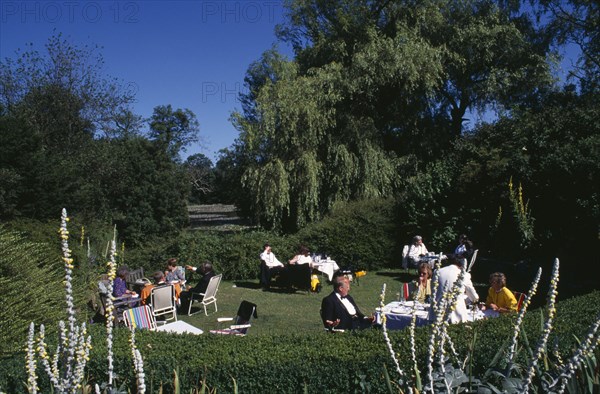 ENGLAND, East Sussex, Glyndebourne, Opera attendees enjoying picnics in the gardens during Opera interval.