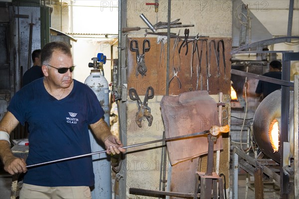 MALTA, Valletta Glass factory, Ta Qali Craft Village, Glass blower manufacturing a glass ornament.