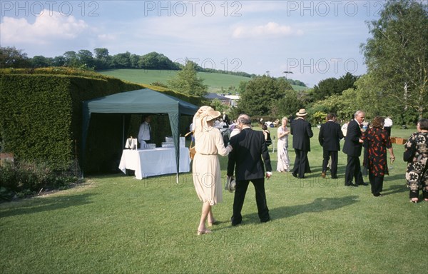 ENGLAND, East Sussex, Glyndebourne, Opera attendees enjoying picnics in the gardens during Opera interval.